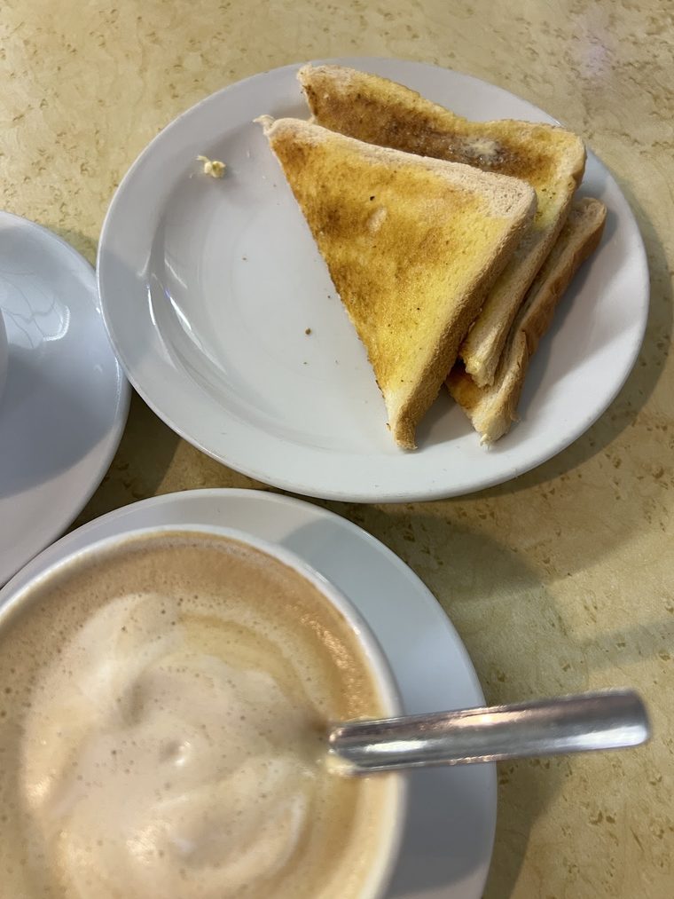 Buttered toast and a large white cup of milky coffee